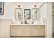 Elegant bathroom featuring double sinks, stylish fixtures, and a well-lit vanity with large framed mirrors at 2939 Osceola St, Denver, CO 80212