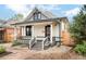 Charming home exterior featuring a covered porch, gray accents, and landscaped front yard at 2939 Osceola St, Denver, CO 80212