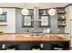 Beautiful kitchen island with butcher block countertop, stainless steel range hood, and pendant lights at 2939 Osceola St, Denver, CO 80212