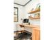 Home office setup featuring a built-in wooden desk, floating shelves, and lots of natural light at 2939 Osceola St, Denver, CO 80212