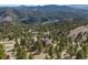 Aerial view of a secluded home nestled among lush trees with stunning mountain views at 2063 Montane E Dr, Golden, CO 80401