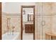 Full bathroom with tiled walls, granite countertop, tiled floors, and convenient walk-in shower with bench at 2063 Montane E Dr, Golden, CO 80401