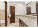 Charming bathroom with tiled walls, granite countertop, a decorative mirror, and wooden door leading to separate room at 2063 Montane E Dr, Golden, CO 80401