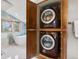 Convenient laundry room featuring stacked washer and dryer in a wooden cabinet located within the spacious primary bathroom at 2063 Montane E Dr, Golden, CO 80401