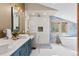 Luxurious bathroom featuring double sinks, modern vanity, soaking tub, and glass-enclosed shower with mountain views at 2063 Montane E Dr, Golden, CO 80401