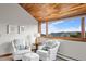 Relaxing sitting area features vaulted wood ceilings, comfortable armchairs, ottoman, and bright windows with mountain views at 2063 Montane E Dr, Golden, CO 80401