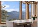 Dining area window frames stunning mountain views with lush, mature pine trees at 2063 Montane E Dr, Golden, CO 80401