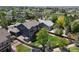 Aerial view of a well-maintained backyard with a deck, shed, mature trees, and a trampoline with mountain views at 879 Quintana Ln, Erie, CO 80516