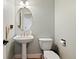 Charming powder room with pedestal sink and oval mirror; a convenient and stylish space for guests at 879 Quintana Ln, Erie, CO 80516