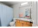 Bathroom features a light-wood vanity, a shower with blue curtain and a large mirror at 879 Quintana Ln, Erie, CO 80516