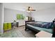 Bright bedroom with a ceiling fan, desk, dresser, bookcase, and large window, providing ample space for a  at 879 Quintana Ln, Erie, CO 80516