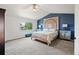 Inviting bedroom featuring a decorative headboard, blue accent wall, and ample natural light from a large window at 879 Quintana Ln, Erie, CO 80516