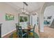 Charming dining area featuring a rustic table, stylish light fixture, and view to the front yard at 879 Quintana Ln, Erie, CO 80516