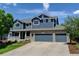 Beautiful two-story home with blue siding, brick accents, and a spacious three-car garage at 879 Quintana Ln, Erie, CO 80516
