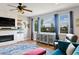 Bright living room featuring a stone fireplace and large windows with neighborhood views at 879 Quintana Ln, Erie, CO 80516