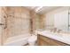 Bathroom featuring a tiled bathtub, vanity, and large mirror at 2225 S Lima Ct, Aurora, CO 80014