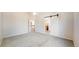 Bright bedroom featuring grey carpet and a sliding barn door leading to the bathroom at 2225 S Lima Ct, Aurora, CO 80014