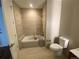 Bright bathroom featuring a bathtub with shower and beige tiling at 4200 W 17Th Ave # 411, Denver, CO 80204