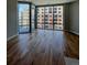 Empty room with hardwood floors and a large window overlooking a brick building at 4200 W 17Th Ave # 411, Denver, CO 80204