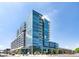 Modern condo with glass facade, outdoor balconies, and street-level landscaping under a bright sky at 4200 W 17Th Ave # 411, Denver, CO 80204