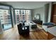 Bright living room with modern furniture, hardwood floors, and large windows with city views at 4200 W 17Th Ave # 411, Denver, CO 80204