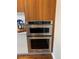 Close-up of stainless steel KitchenAid double oven with sleek wood cabinetry at 4200 W 17Th Ave # 411, Denver, CO 80204
