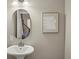 Stylish powder room with a pedestal sink, modern mirror, and tasteful decor, creating an inviting space at 5708 S Galena St, Greenwood Village, CO 80111