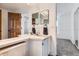 Cozy bathroom features a dual vanity with modern fixtures, tiled backsplash, and a mirror at 1737 Jules Ct, Highlands Ranch, CO 80126
