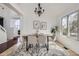 Elegant dining room featuring modern chandelier, neutral decor, and sun-filled view from the window at 1737 Jules Ct, Highlands Ranch, CO 80126