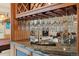Wet bar features granite countertops, wooden cabinets, and suspended stemware rack at 5881 Deer Meadow Trl, Golden, CO 80403