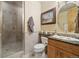 Well-lit bathroom with tiled shower, granite counters, and framed vanity mirror at 5881 Deer Meadow Trl, Golden, CO 80403