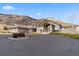 Inviting brick home featuring a circular driveway with unique vintage wagon wheel accent and mountain views at 5881 Deer Meadow Trl, Golden, CO 80403