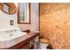 Small bathroom with an antique sink and toilet, window, and wood wall feature at 10419 Christopher Dr, Conifer, CO 80433