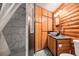 Modern bathroom featuring stone tiled shower and wooden vanity at 10419 Christopher Dr, Conifer, CO 80433