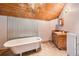 Bathroom with a vintage clawfoot tub, wooden vanity, and unique corrugated metal accents at 10419 Christopher Dr, Conifer, CO 80433