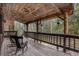 A spacious deck featuring rocking chairs and a stunning view of a lush forest, perfect for relaxation and outdoor enjoyment at 10419 Christopher Dr, Conifer, CO 80433