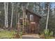 Cozy cabin with unique architectural details nestled among a peaceful forest setting at 10419 Christopher Dr, Conifer, CO 80433