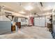 Spacious unfinished garage with two doors, ample storage, and a red entry door leading to the house at 10419 Christopher Dr, Conifer, CO 80433
