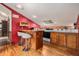 Cozy kitchen with red accent wall, wooden cabinets, bar, and skylight at 10419 Christopher Dr, Conifer, CO 80433