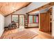 Light-filled living room features wood-beamed ceilings, hardwood floors, and scenic views at 10419 Christopher Dr, Conifer, CO 80433