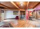 Living room with a vintage stove, hardwood floors, wooden beams, and a cozy dining nook at 10419 Christopher Dr, Conifer, CO 80433