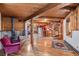 Open-concept space featuring hardwood floors, exposed wooden beams, a vintage stove, and a spiral staircase at 10419 Christopher Dr, Conifer, CO 80433