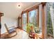Cozy sunroom with a rocking chair and large windows, offering serene views of the surrounding landscape at 10419 Christopher Dr, Conifer, CO 80433