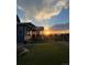 Serene backyard featuring lush green lawn, cozy outdoor seating, and picturesque sunset at 8981 Bellsong Circle Cir, Littleton, CO 80125