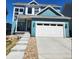 Charming blue two-story home with a spacious two-car garage and a well-manicured lawn at 8981 Bellsong Circle Cir, Littleton, CO 80125