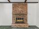 Close-up of a brick fireplace with a glass door insert at 9327 W Arizona Ave, Lakewood, CO 80232