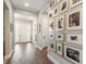 Welcoming entryway featuring hardwood floors and a stylish gallery wall with framed Gathering photos at 14160 Ivanhoe St, Thornton, CO 80602