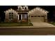Charming home exterior illuminated with beautiful, soft holiday lights at night at 14160 Ivanhoe St, Thornton, CO 80602