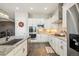 Bright kitchen featuring white cabinets, granite countertops, stainless steel appliances, and hardwood floors at 14160 Ivanhoe St, Thornton, CO 80602