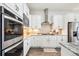 A modern kitchen with white cabinets, stainless steel appliances, and a stylish backsplash at 14160 Ivanhoe St, Thornton, CO 80602
